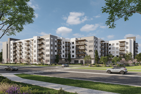 A modern apartment complex with cars parked in front.